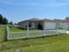 Single-story home with green grass and a white picket fence, offering classic curb appeal at 909 San Paulo Way, Kissimmee, FL 34758
