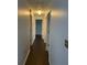 A long hallway with neutral walls and dark wood-look floors at 909 San Paulo Way, Kissimmee, FL 34758