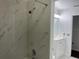 Updated shower with marble-look tile, alongside a modern bathroom with white vanity at 909 San Paulo Way, Kissimmee, FL 34758