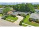 Aerial view of a well-maintained single-story home featuring a circular driveway, lush landscaping, and mature trees in a quiet neighborhood at 1017 Manchester Cir, Winter Park, FL 32792