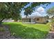 Lush backyard featuring a well-maintained lawn, mature trees, and a screened-in patio for outdoor enjoyment at 1017 Manchester Cir, Winter Park, FL 32792
