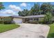 Beautiful single-story home featuring an attached two-car garage, well-kept lawn, and a long driveway, blending comfort and charm at 1017 Manchester Cir, Winter Park, FL 32792