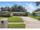 Attractive single-story house with a manicured lawn, vibrant landscaping, and a convenient circular driveway leading to the front entrance at 1017 Manchester Cir, Winter Park, FL 32792