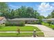 Well-maintained single story home with a lush green lawn, complimented by mature trees, shrubbery, and a convenient circular driveway at 1017 Manchester Cir, Winter Park, FL 32792