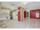 Open-concept kitchen with white appliances and tile flooring leading to multiple rooms, enhanced with ceiling fans at 1017 Manchester Cir, Winter Park, FL 32792