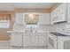 Clean kitchen showcasing white cabinetry, white appliances, and a window over the sink with tile backsplash at 1017 Manchester Cir, Winter Park, FL 32792