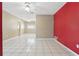 Bright, open living area with white tile flooring, a ceiling fan, and red accent wall with ample natural light at 1017 Manchester Cir, Winter Park, FL 32792