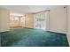 Large living room with glass sliding door, lots of light, and green carpet at 1017 Manchester Cir, Winter Park, FL 32792