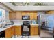Functional kitchen with stainless steel refrigerator, oak cabinetry, and white countertops at 116 Candlewick Ct, Sanford, FL 32771