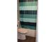 Cozy bathroom featuring a tub with a colorful striped shower curtain and a white toilet at 1212 Leon Ln, Daytona Beach, FL 32117