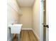 Well-lit laundry room featuring a utility sink, storage shelving, and vinyl plank flooring at 1331 19Th St, Orlando, FL 32805