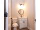 Stylish powder room featuring a modern vanity, round mirror, and contemporary lighting fixtures at 1331 19Th St, Orlando, FL 32805
