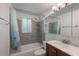 Bathroom with a shower-tub combination, white tile, dark vanity, and updated fixtures at 1343 Charlotte St, Altamonte Springs, FL 32701