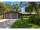 Charming home featuring a stone facade, two-car garage, lush landscaping, and a well-manicured lawn at 1343 Charlotte St, Altamonte Springs, FL 32701