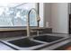 Close-up of a deep kitchen sink and modern faucet, complemented by natural light streaming through the window at 1343 Charlotte St, Altamonte Springs, FL 32701