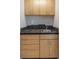 Close-up of the kitchenette with light wood cabinets, dark countertops, and a stainless steel sink at 1343 Charlotte St, Altamonte Springs, FL 32701