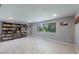 Spacious living room features a large window, tile floors, and a cozy atmosphere, enhanced by a bookshelf at 1343 Charlotte St, Altamonte Springs, FL 32701