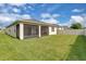 Spacious backyard with green grass, a screened in lanai and a white fence for privacy at 1425 Lone Wood Blvd, Orlando, FL 32828