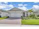 Charming single-story home featuring a brick driveway, two-car garage, and a lush landscaped yard at 1425 Lone Wood Blvd, Orlando, FL 32828