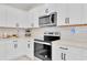 Modern kitchen features stainless steel appliances and white cabinets with black hardware at 1425 Lone Wood Blvd, Orlando, FL 32828
