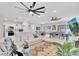 Open concept living room with white furniture, ceiling fans, and access to dining and kitchen at 1425 Lone Wood Blvd, Orlando, FL 32828