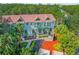 Aerial view of townhomes with lush landscaping, red tile roofs, and green accents at 14501 Damai Ln, Orlando, FL 32821