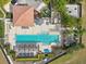 Aerial view of sparkling pool with lounge chairs, pergola, tile decking and manicured landscaping at 14501 Damai Ln, Orlando, FL 32821