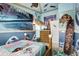 The bedroom features Moana themed decor, custom wave murals, and unique decorative surfboards at 14501 Damai Ln, Orlando, FL 32821