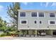 Exterior view of townhome featuring car parking under the building and manicured landscaping at 14501 Damai Ln, Orlando, FL 32821