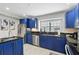 Well-lit kitchen with stainless steel appliances, granite countertops, and blue cabinets at 14501 Damai Ln, Orlando, FL 32821