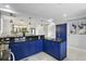 Open kitchen with navy blue cabinetry, granite counters, island sink, and an open view of the dining room and staircase at 14501 Damai Ln, Orlando, FL 32821