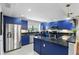 Bright kitchen with navy blue cabinets, stainless steel appliances, granite counters, and updated pendant lighting at 14501 Damai Ln, Orlando, FL 32821