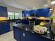 Modern kitchen with blue cabinets, granite countertops, and stainless-steel appliances at 14501 Damai Ln, Orlando, FL 32821