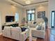Spacious living room featuring hardwood floors, comfortable seating, and a tray ceiling at 14501 Damai Ln, Orlando, FL 32821