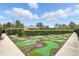 Fun mini golf area in a community featuring manicured lawns, hedges, and landscaping at 14501 Damai Ln, Orlando, FL 32821