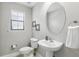 Cozy powder room with pedestal sink, toilet, and a window for natural light at 14501 Damai Ln, Orlando, FL 32821