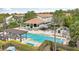 Community swimming pool features a pavilion, lounge seating, palm trees and meticulously maintained landscaping at 14501 Damai Ln, Orlando, FL 32821
