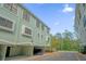 Exterior view of a condo building featuring covered parking, neutral-colored facades, and well-maintained landscaping at 14513 Damai Ln, Orlando, FL 32821