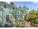 Charming townhome with green paint, stone accents, and a well-manicured landscape with palm trees at 14513 Damai Ln, Orlando, FL 32821