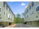 Exterior view of the condo buildings featuring covered parking, and neutral-colored facades with multiple windows at 14513 Damai Ln, Orlando, FL 32821