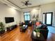 Open living room features hardwood floors, tray ceiling, and comfortable leather seating arrangements at 14513 Damai Ln, Orlando, FL 32821