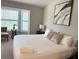 Serene bedroom with large window, neutral tones, and comfortable bed with decorative pillows at 14513 Damai Ln, Orlando, FL 32821