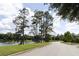 Scenic pond view with lush trees and calm waters along a paved road at 1486 Farrindon Cir, Lake Mary, FL 32746