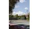 Outdoor tennis court with green surfacing and a net, surrounded by trees and greenery at 1486 Farrindon Cir, Lake Mary, FL 32746