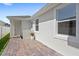 Home's backyard with white stucco exterior, brick patio, and well-manicured lawn at 15444 Lebeau Loop, Winter Garden, FL 34787