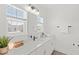 Bright bathroom boasts a quartz countertop vanity and a large window providing natural light at 15444 Lebeau Loop, Winter Garden, FL 34787