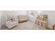 Cozy Bedroom with neutral tones, featuring a rocking chair, crib, and storage shelves at 15444 Lebeau Loop, Winter Garden, FL 34787