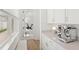 Butler pantry with an espresso machine and views through to a fitness room with a Peloton exercise bike at 15444 Lebeau Loop, Winter Garden, FL 34787