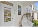 Inviting front porch with a cozy egg chair, white door with glass insert, and address numbers at 15444 Lebeau Loop, Winter Garden, FL 34787