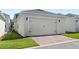 Spacious two-car garage with a brick paved driveway and well-maintained lawn at 15444 Lebeau Loop, Winter Garden, FL 34787